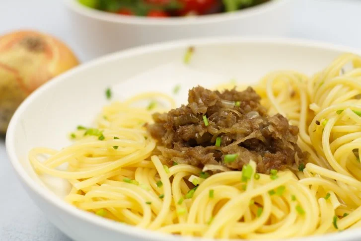 Een bord Bigoli in salsa met heerlijke ansjovis en ui, traditioneel Italiaans gerecht.
