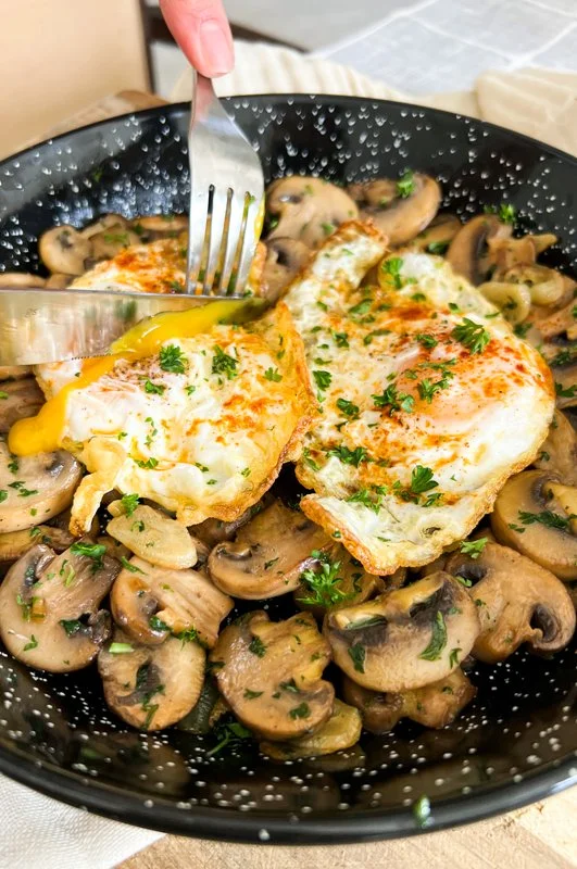 Eieren met champignons in knoflooksaus op een bord
