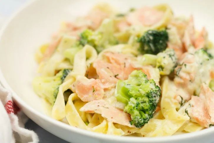 Pasta met broccoli en zalm in dille-roomsaus op een bord