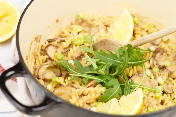 Pasta met tonijn in romige champignonsaus op een bord geserveerd.