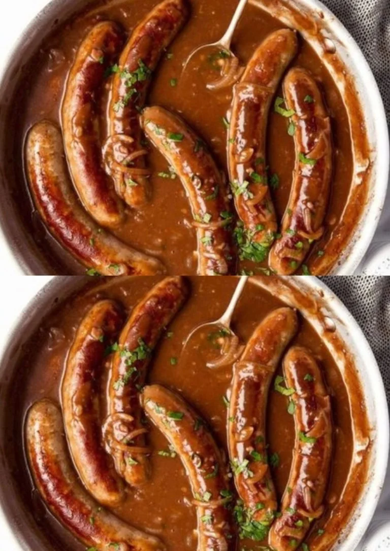 Bratwurst met romige aardappelpuree en uienjus op een bord