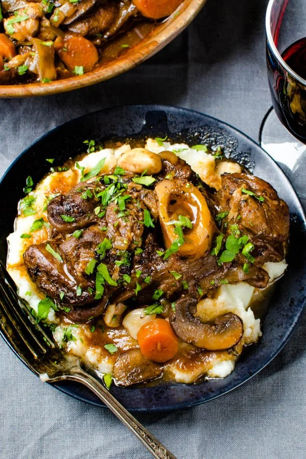 Osso buco recept met gestoofde kalfsshank in knoflook wijn saus