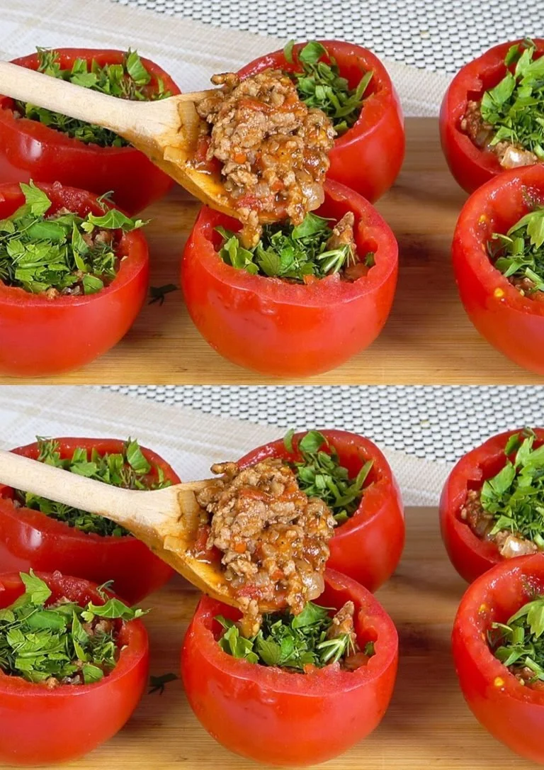 Gevulde tomaten met kruiden en gehakt, geserveerd op een bord.
