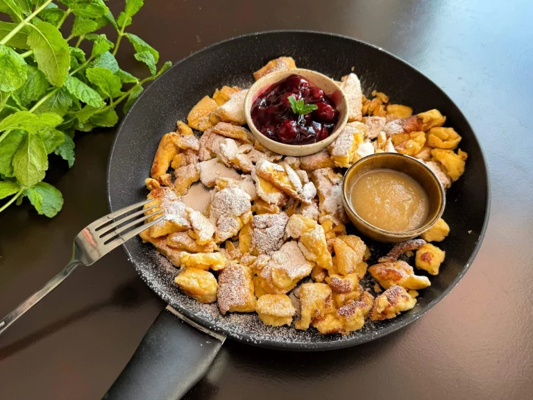 Heerlijke Kaiserschmarrn geserveerd met poedersuiker en fruit.