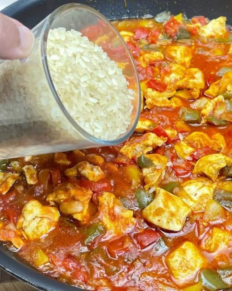 Kip met rijst en paprika geserveerd op een bord