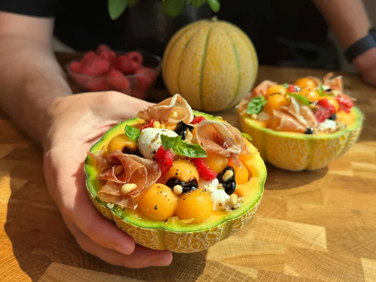 Sliced meloen met ham op een houten bord