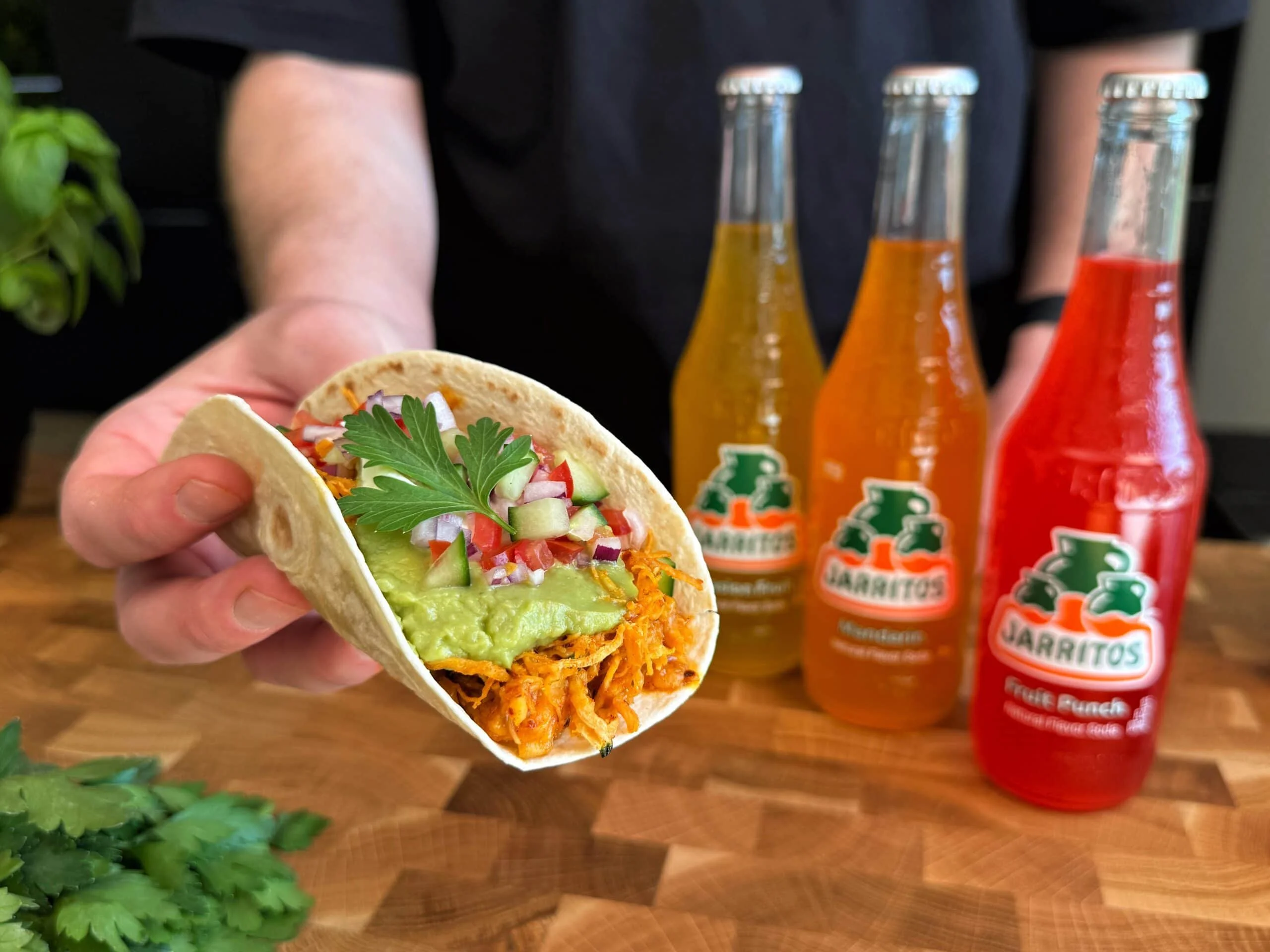 Beeld van plakkerige getrokken kip tacos in een tortilla met toppings