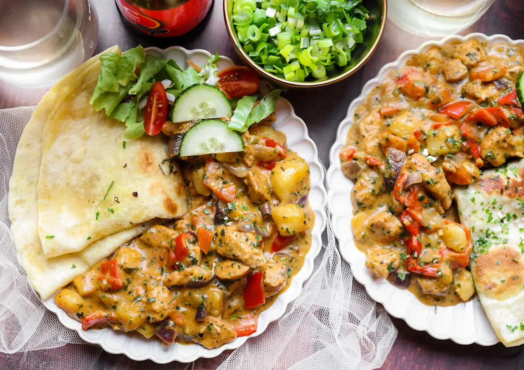 Kippendijen met groenten in romige saus op een bord