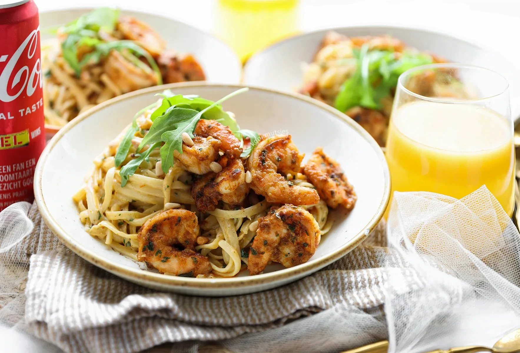 Linguine met garnalen geserveerd met verse kruiden en citroen.