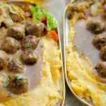 Pompoenpuree met gehaktballetjes in saus op een bord