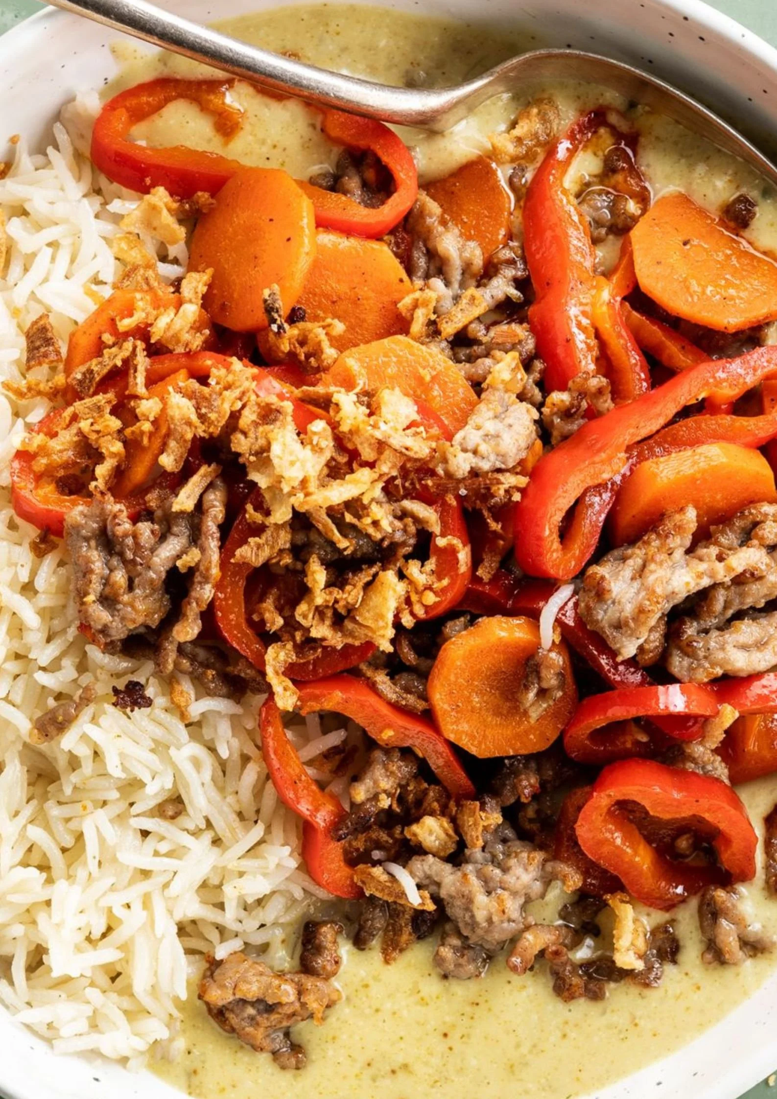 Rijst met gekruid gehakt in romige curry saus op een bord