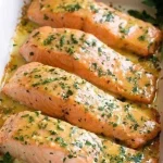 Zalmfilet met knoflookboter en citroen op een bord