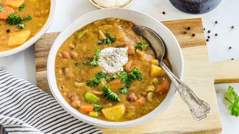 Hartige bruine bonensoep met ingrediënten en kruiden in een kom.