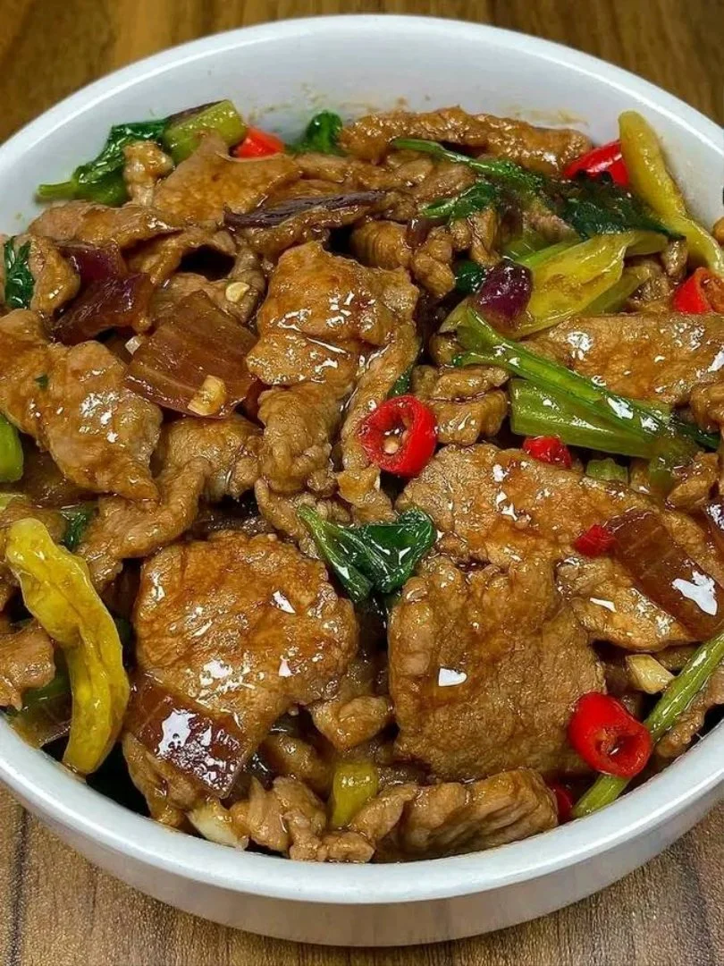 Roergebakken rundvlees met kleurrijke groenten op een bord