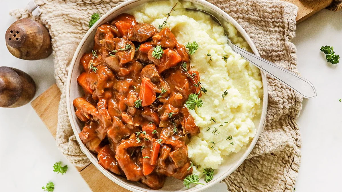 Vegan boeuf bourguignon met groenten en kruiden in een pannetje