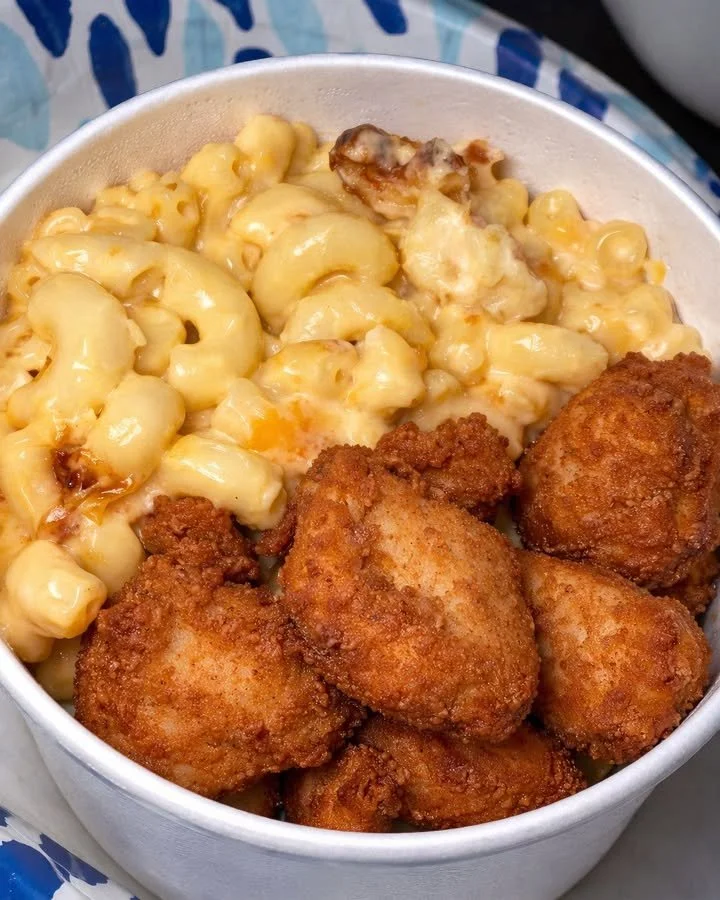 Krokante kippenbites met romige macaroni en kaas op een bord