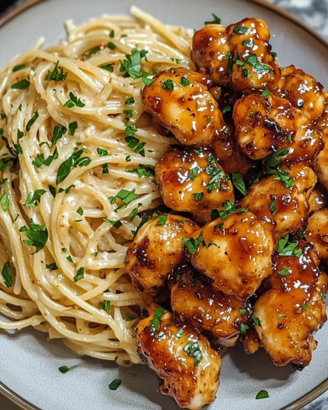 Romige spaghetti met honing knoflook kip op een bord