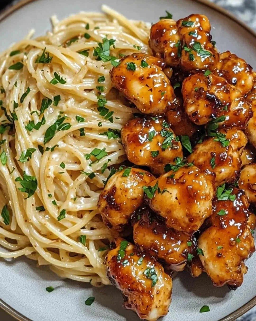Romige spaghetti met honing knoflook kip op een bord