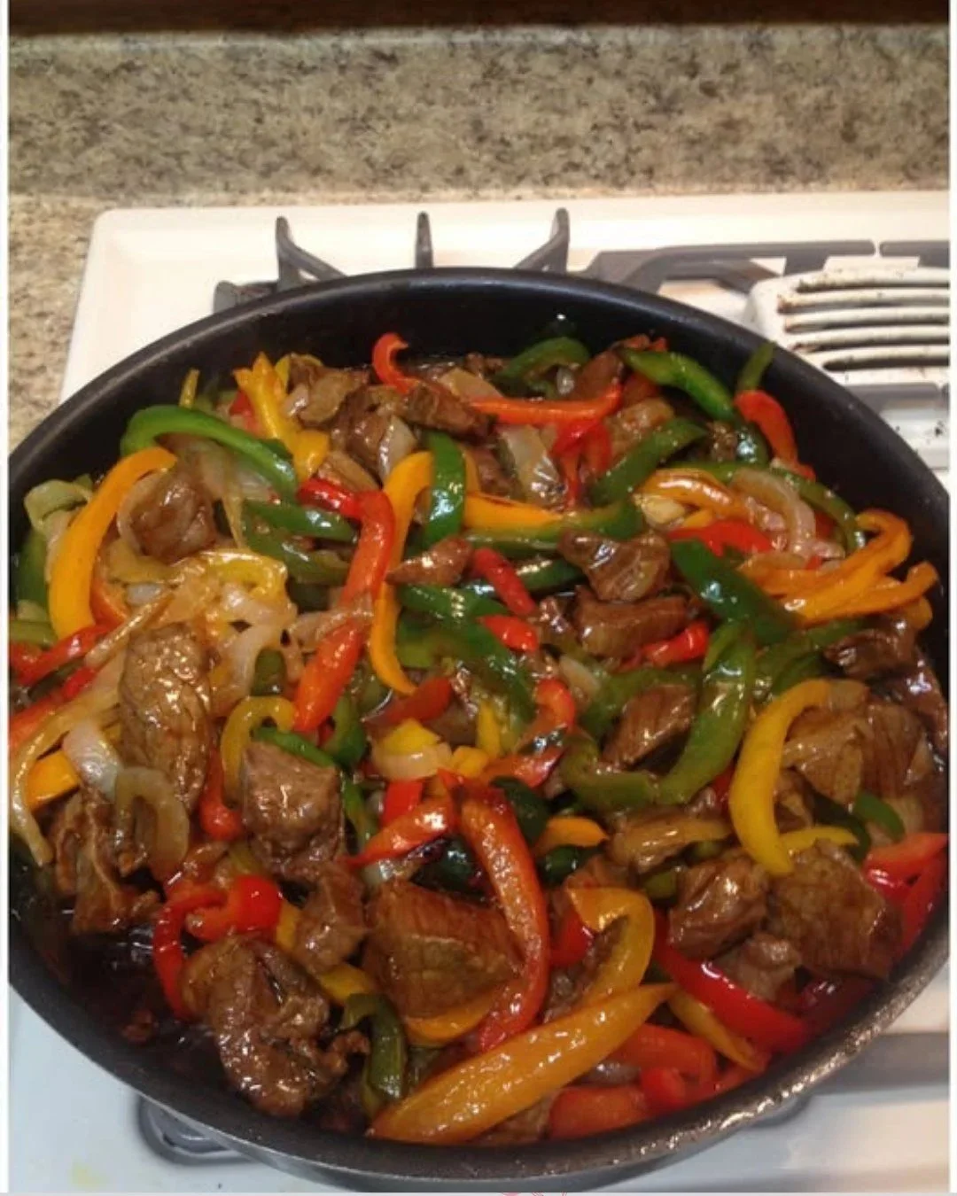 Steak met paprika en ui op een bord, perfect bereid voor een smaakvolle maaltijd.