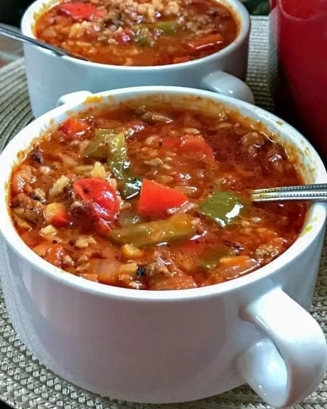 Bowl van smakelijke gevulde paprikasoep met verse ingrediënten