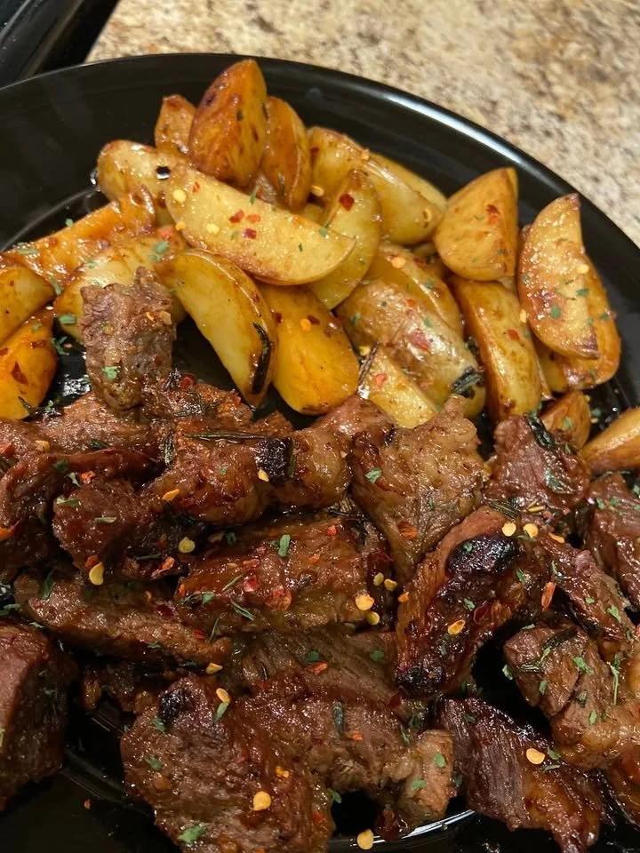 Biefstuk met knoflook-kruidenaardappelen bereid in een koekenpan.