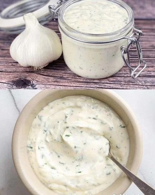 Romige knoflook-yoghurtsaus in een kom met ingrediënten op de achtergrond