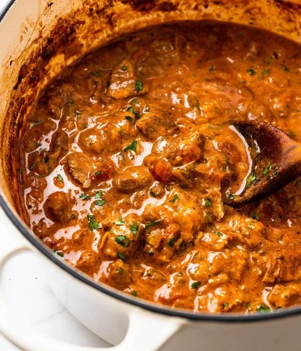 Een bord met smakelijke Duitse Goulash, geserveerd met brood.