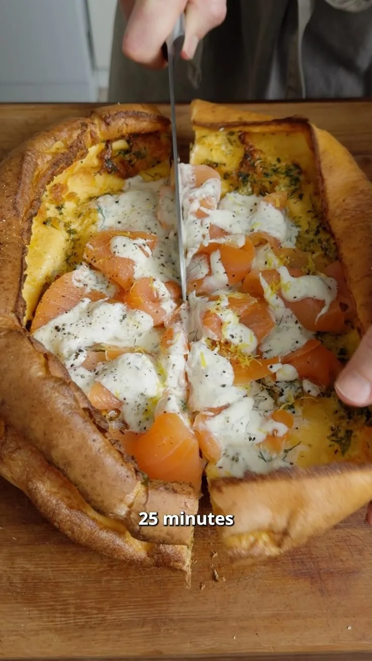 Heerlijke Dutch Baby pannenkoek uit de oven met poedersuiker en fruit.
