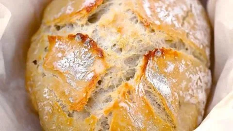 Vers gebakken Kruidige Korstbrood uit de Dutch Oven met kruiden en knapperige korst.