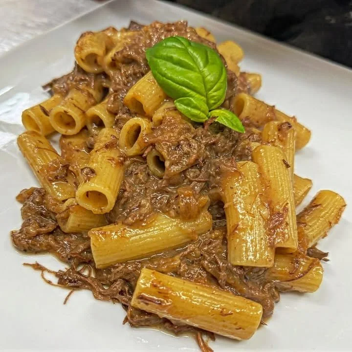 Een kom Genovese Saus met vers ingrediënten en kruiden, ideaal voor gerechten.