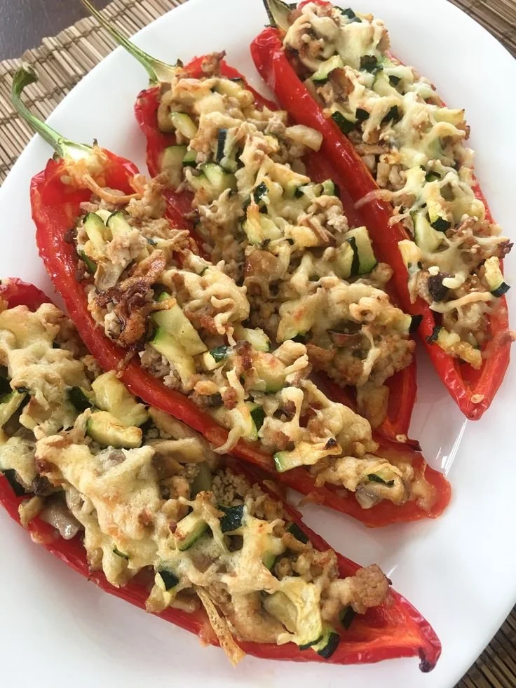 Gevulde punt paprika met kipgehakt en groenten op een bord