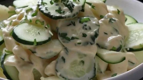 Bowl met Nederlandse komkommersalade met verse ingrediënten en kruiden