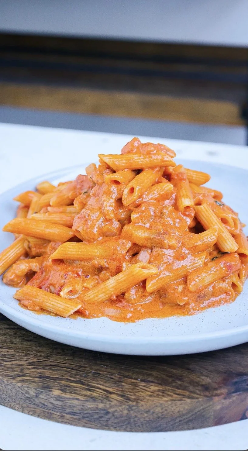 Penne alla Vodka met romige saus en verse kruiden op een bord