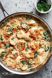 Romige Toscaanse garnalen met pasta en kruiden in een pan