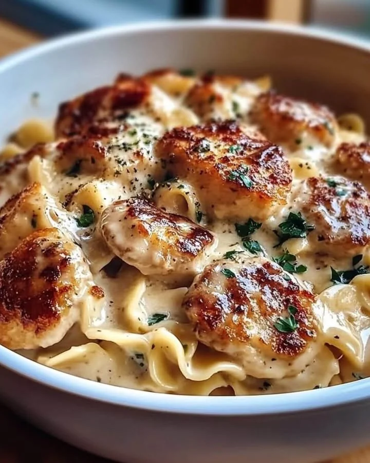 Kip met champignonsaus en geboterde noedels op een bord