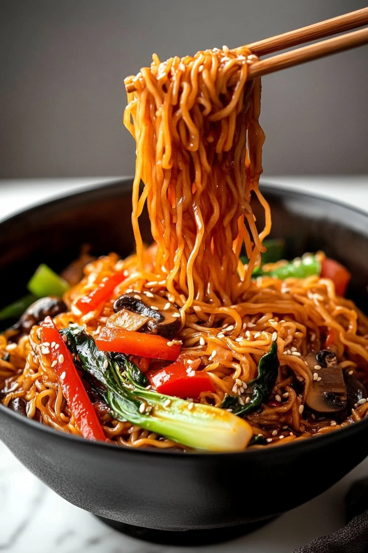 Een kom Lo Mein met kleurrijke groenten en smaakvolle saus.