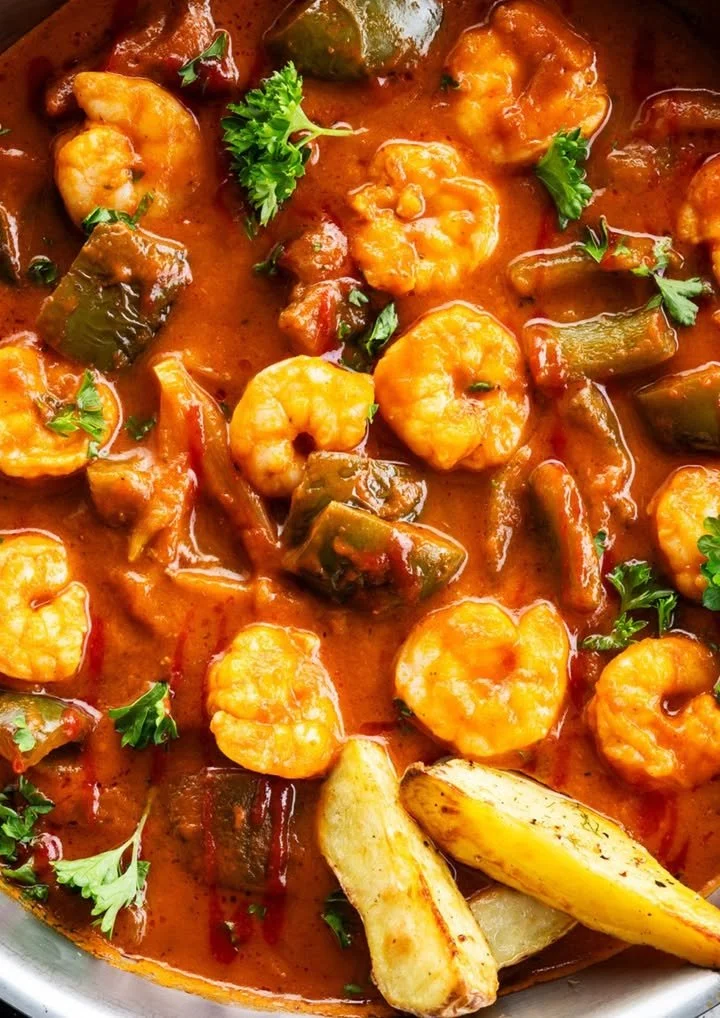Pittige scampi met krokante aardappelwedges op een bord