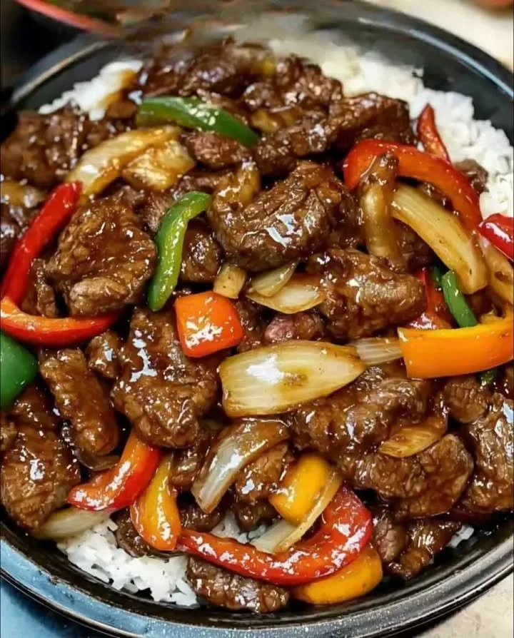 Biefstuk met uien en paprika’s in een pan bereid, een eenvoudig recept.